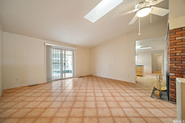 empty room with ceiling fan and vaulted ceiling with skylight