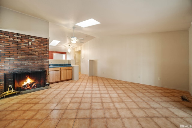 unfurnished living room with vaulted ceiling, ceiling fan, and a fireplace