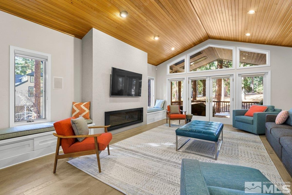 living room featuring a large fireplace, lofted ceiling, wood ceiling, and light wood-type flooring