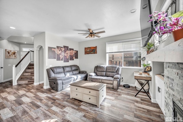 living room with ceiling fan, hardwood / wood-style flooring, and a fireplace