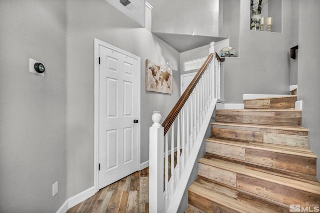 staircase featuring a chandelier and wood-type flooring