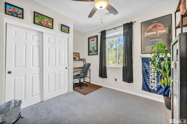 carpeted office space featuring ceiling fan