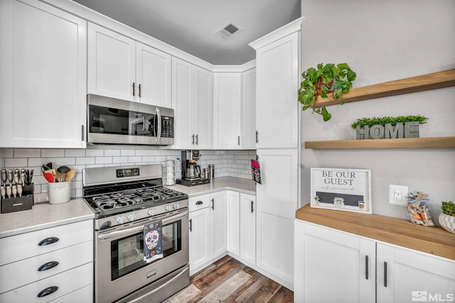 kitchen with light hardwood / wood-style flooring, backsplash, stainless steel appliances, and white cabinetry