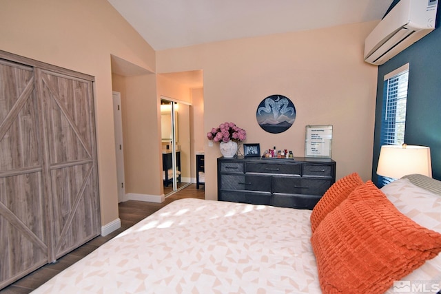 bedroom with an AC wall unit, dark hardwood / wood-style floors, a closet, and vaulted ceiling