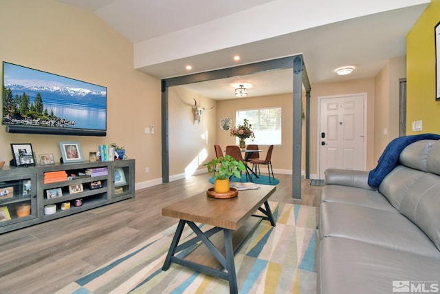 living room with light hardwood / wood-style flooring and vaulted ceiling