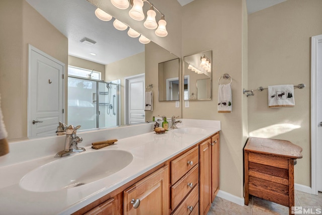 bathroom with a shower with shower door, vanity, and tile patterned floors