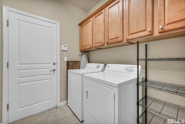 laundry room featuring washer and clothes dryer, light tile patterned floors, and cabinets