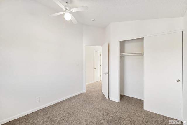 unfurnished bedroom with ceiling fan, carpet, a closet, lofted ceiling, and a textured ceiling