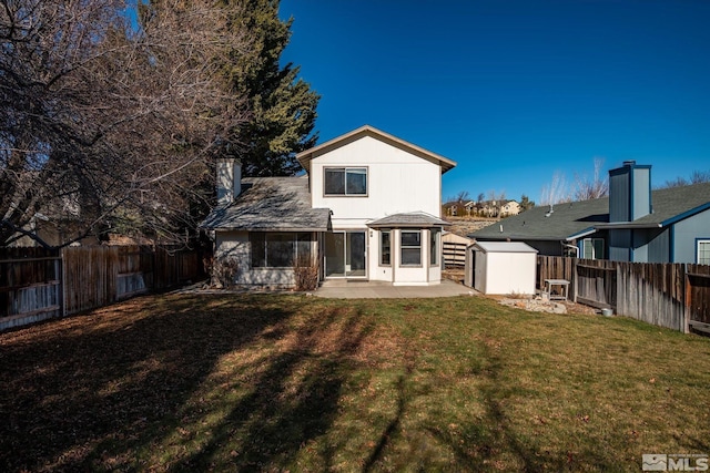 back of house with a lawn, a storage shed, and a patio