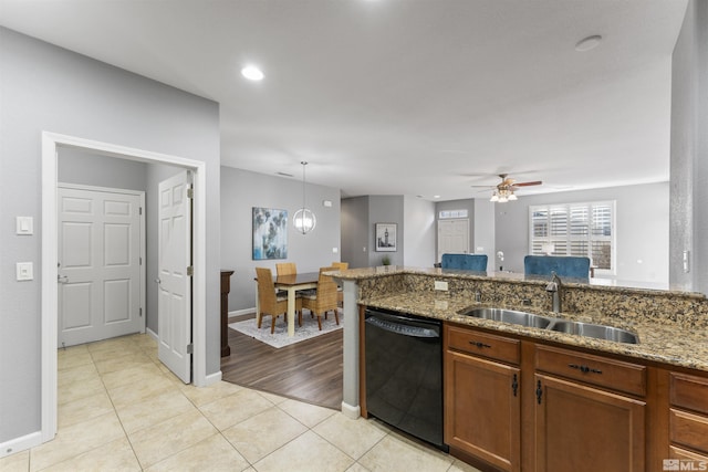 kitchen featuring ceiling fan with notable chandelier, black dishwasher, sink, stone countertops, and light tile patterned flooring