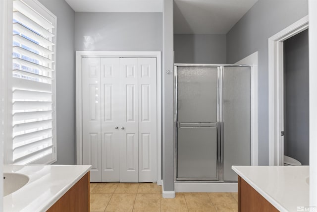 bathroom featuring a shower with shower door, tile patterned floors, vanity, and toilet