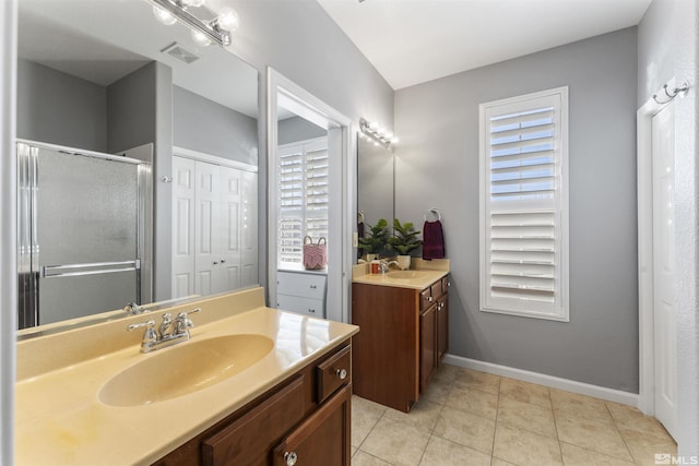 bathroom featuring tile patterned flooring, a shower with shower door, and vanity