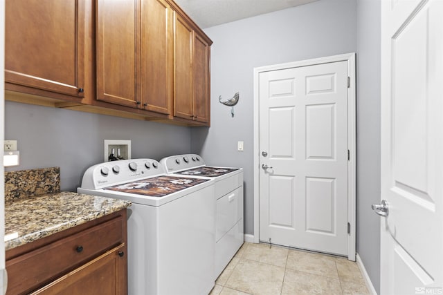 washroom featuring cabinets, light tile patterned floors, and washing machine and dryer