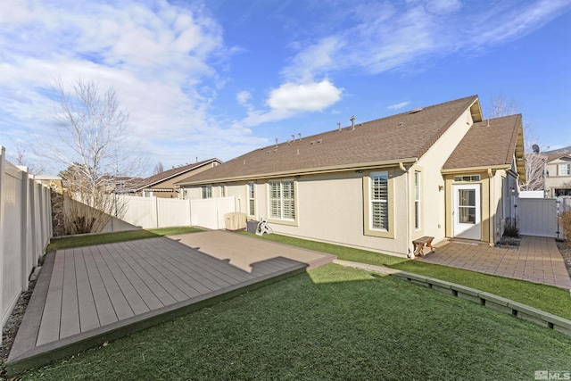 rear view of property with a lawn, a patio area, and a wooden deck