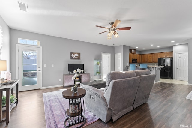 living room with ceiling fan and dark hardwood / wood-style flooring