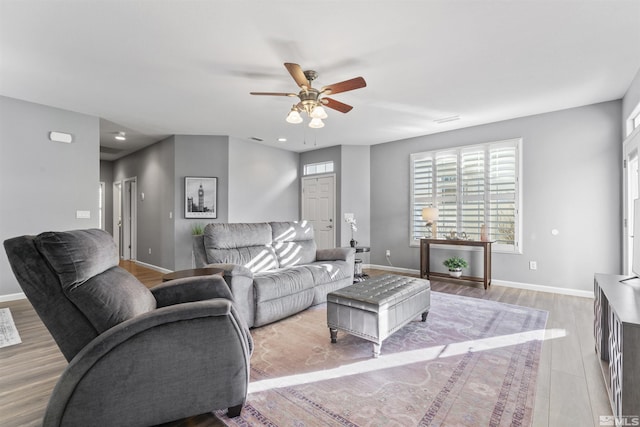 living room featuring ceiling fan and light hardwood / wood-style floors