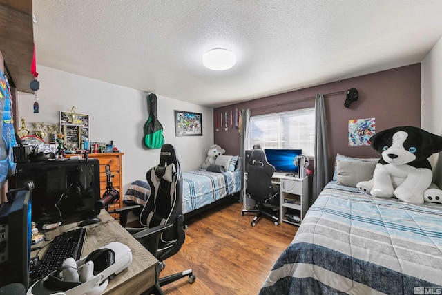 bedroom featuring wood-type flooring and a textured ceiling