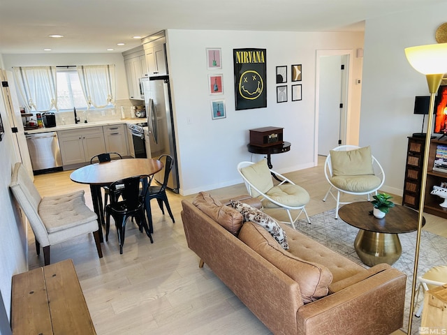 living room featuring light wood-type flooring and sink