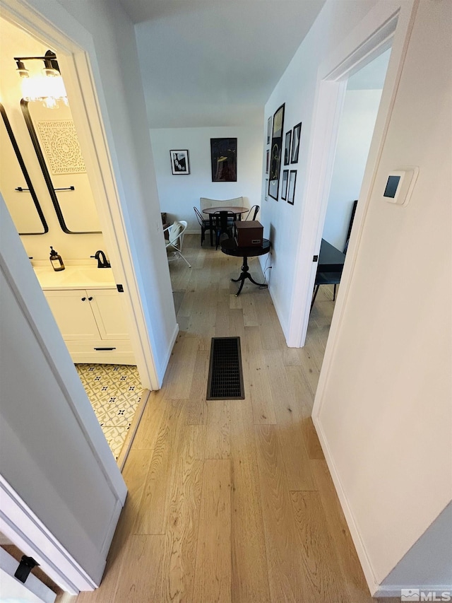 corridor with light hardwood / wood-style flooring