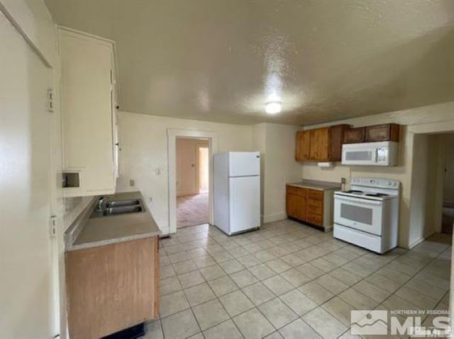 kitchen with sink, white appliances, and a textured ceiling