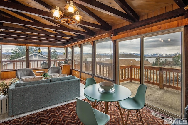 sunroom / solarium with wood ceiling, a notable chandelier, and vaulted ceiling with beams