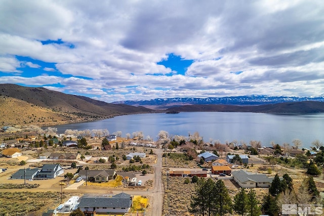 birds eye view of property with a water and mountain view