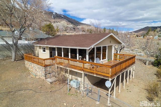 rear view of property with a deck with mountain view