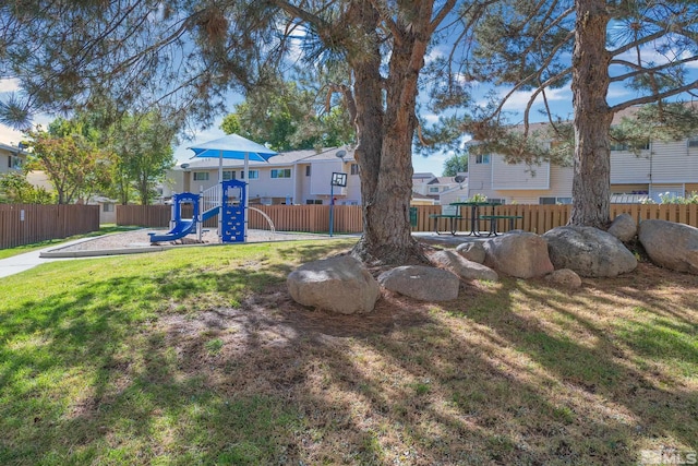 view of yard featuring a playground, fence, and a residential view