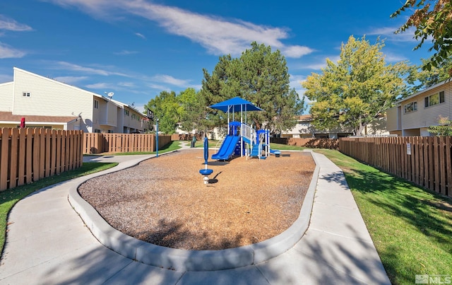 communal playground with a yard, a residential view, and fence