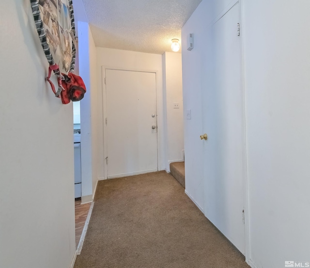 hallway with carpet floors and a textured ceiling