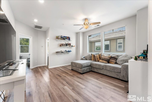 living room featuring ceiling fan and light hardwood / wood-style flooring