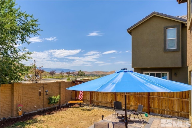 view of yard with a mountain view and a patio area