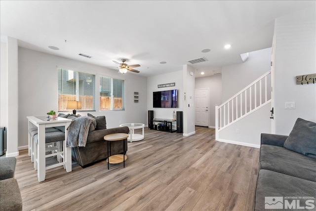 living room with light wood-type flooring and ceiling fan