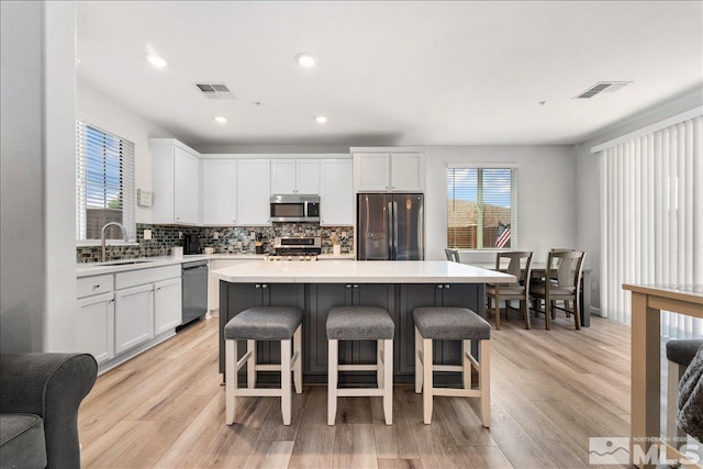 kitchen featuring sink, white cabinetry, a center island, and stainless steel appliances