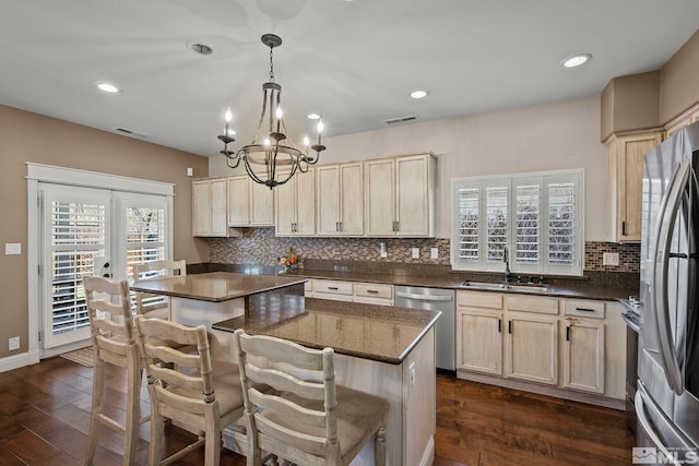 kitchen featuring stainless steel appliances, dark hardwood / wood-style floors, a center island, pendant lighting, and sink