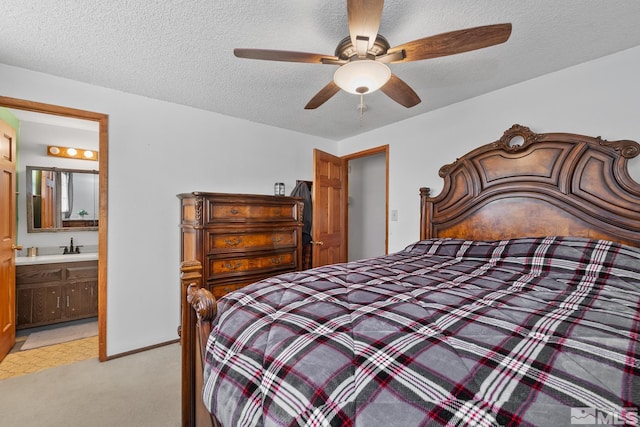 bedroom with ceiling fan, light carpet, connected bathroom, and a textured ceiling