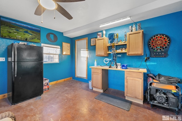 kitchen with ceiling fan, concrete flooring, light brown cabinets, and black fridge