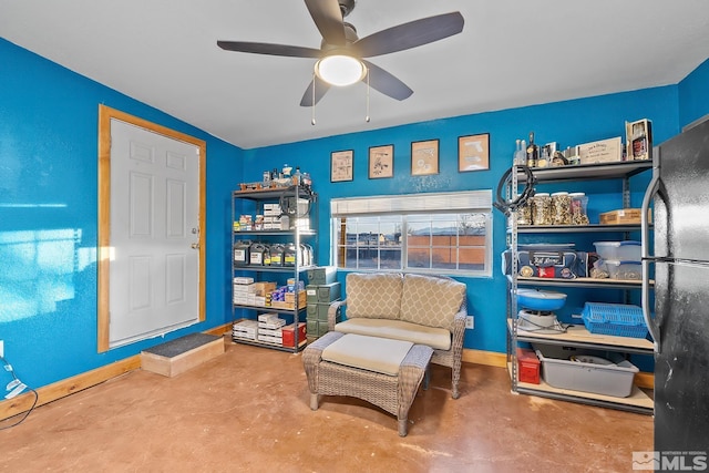 sitting room with ceiling fan and concrete flooring