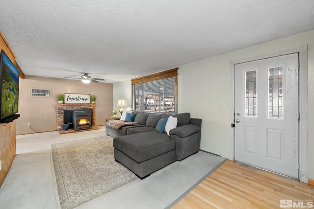 living room with a textured ceiling, ceiling fan, and hardwood / wood-style floors