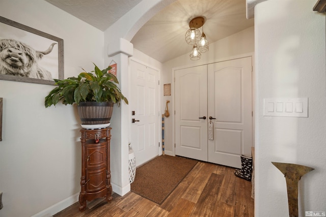 foyer featuring dark hardwood / wood-style flooring and lofted ceiling