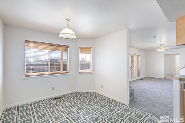 carpeted spare room featuring ceiling fan