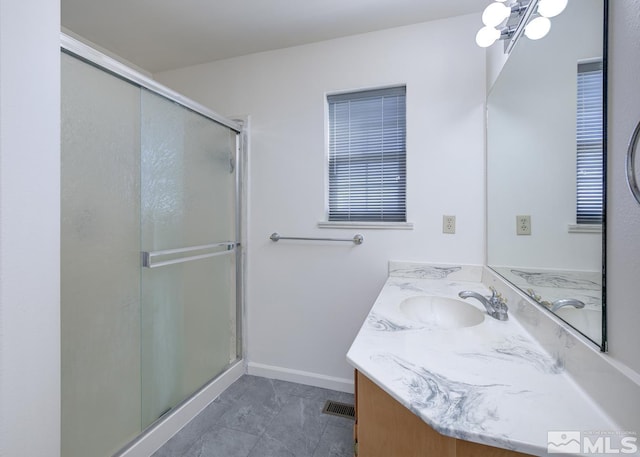 bathroom with a shower with shower door, vanity, and a chandelier