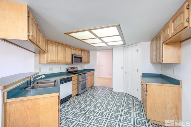 kitchen featuring stainless steel appliances, light brown cabinets, and sink