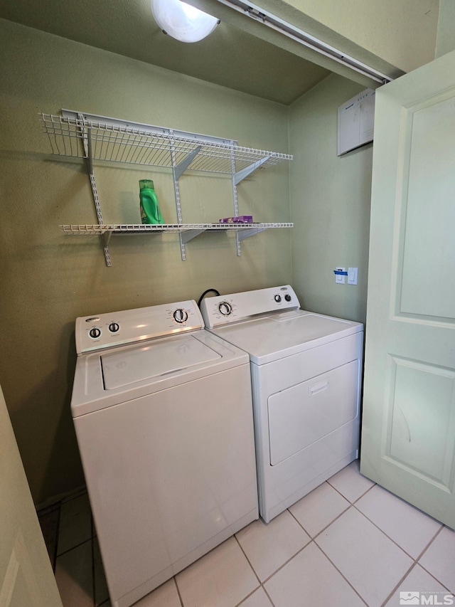 clothes washing area with light tile patterned floors and washing machine and clothes dryer