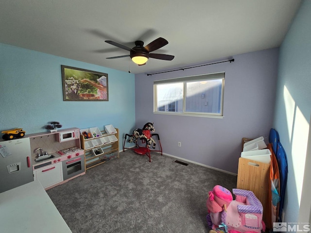 game room with dark carpet and ceiling fan