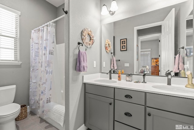 full bathroom with tile patterned floors, toilet, vanity, and shower / bath combo