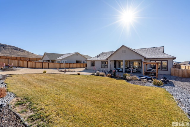 back of property with a patio area and a yard