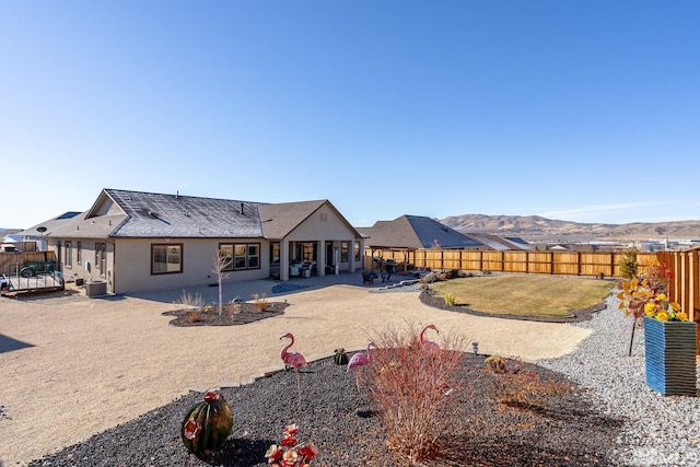 rear view of house with a patio area and a mountain view