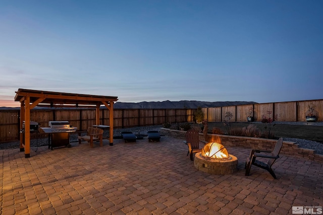 patio terrace at dusk with a mountain view and a fire pit