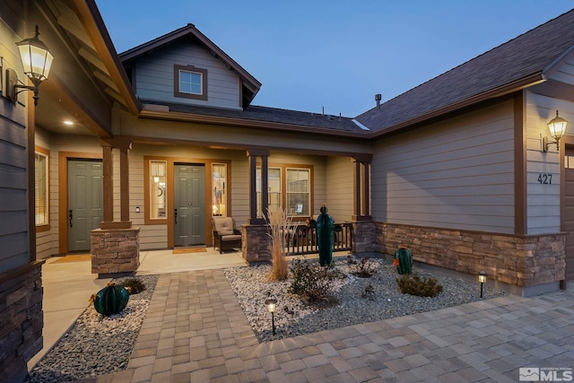 view of exterior entry featuring covered porch